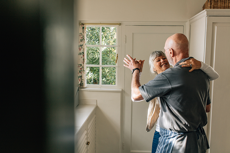 retired couple dancing in kitchen