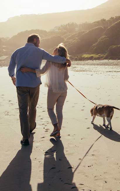 protected lifetime income couple with dog on beach